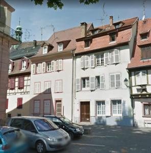 two cars parked in front of a white building at Le Clos bartholdi in Colmar