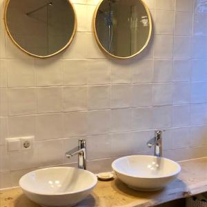 two sinks in a bathroom with two mirrors at Familiehuis Lytse Miede in Formerum