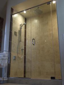 a bathroom with a shower stall with a glass door at Appart-Hôtel Le Vincent in Quebec City