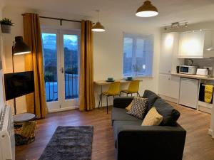 a living room with a couch and a kitchen at Lower Highview - Self Catering Apartment, fpventures Stroud in Stroud