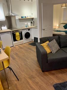 a living room with a couch and a kitchen at Lower Highview - Self Catering Apartment, fpventures Stroud in Stroud
