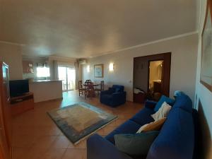 uma sala de estar com um sofá azul e uma cozinha em Great Flat Beach and Pool em Alvor