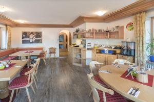 ein Restaurant mit Tischen und Stühlen und eine Küche in der Unterkunft Gästehaus Birkenhof in Oberstdorf