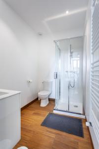 a bathroom with a toilet and a glass shower at La maison des couturières in Cluny