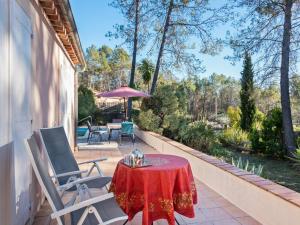 un patio con mesa y sillas en Lavish Villa in Bagnols en For t with Swimming Pool, en Bagnols-en-Forêt