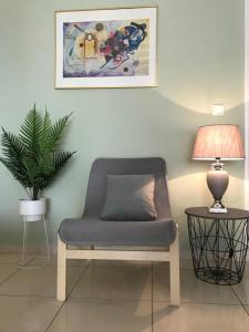 a chair in a room with a lamp and a plant at Irini Apartments in Kavála
