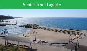 a beach scene with a train on the tracks at Lagarto Hostel Tenerife in Valle de Guerra
