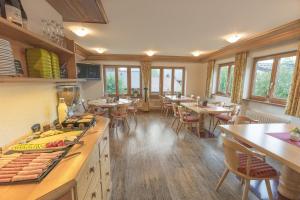 un ristorante con tavoli e sedie in una stanza di Gästehaus Birkenhof a Oberstdorf Altre 38 foto