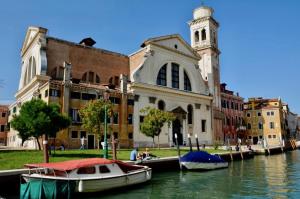 een gebouw met een klokkentoren en boten in het water bij CA GRIMANI private terrace in Venetië