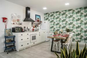 a kitchen with a table and a white refrigerator at Deluxe Rue Bohème in Plasencia