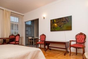 une chambre d'hôtel avec un lit, une table et des chaises dans l'établissement KaunasInn - AM, à Kaunas