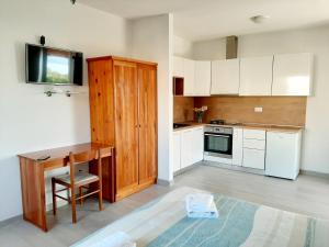 a kitchen with white cabinets and a wooden desk at Apartment Grace Cavtat - SEA VIEW in Cavtat