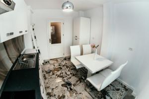 蒂米什瓦拉的住宿－Apartament de lux ultramodern in zona centrala，一间设有桌椅和铺着碎地板的客房
