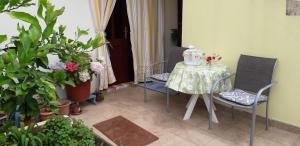 una stanza con tavolo, sedie e piante di Apartments Bilić a Vis