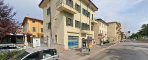 un coche aparcado frente a un edificio en una calle en Appartamento TOPAZIO, en Verona