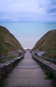 a stairway leading down to the beach with the ocean at VVF Normandie Veules-les-Roses in Veules-les-Roses