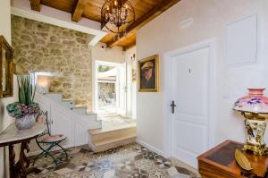 a hallway with a stone wall and a white door at Apartments Villa Agava in Cavtat