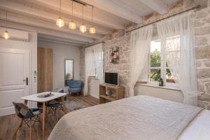 - une chambre avec un lit, une table et une télévision dans l'établissement Apartments Villa Agava, à Cavtat