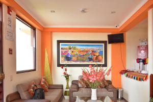 una sala de estar con 2 sofás y una pintura en la pared en Pumas Cusco Hotel, en Cusco