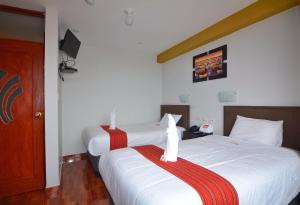 dos camas sentadas una al lado de la otra en un dormitorio en Pumas Cusco Hotel, en Cusco
