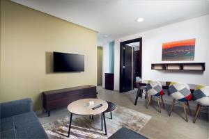 達曼的住宿－TIME Dammam Residence，客厅配有沙发和桌子