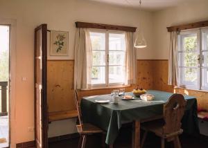 a dining room table with a green tablecloth and two windows at 2 Chalets Innsbruck in Innsbruck