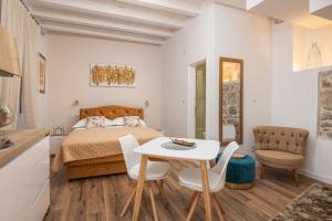 um quarto com uma cama, uma mesa e cadeiras em Apartments Villa Agava em Cavtat
