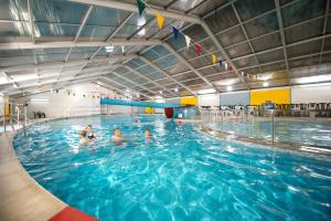 un groupe de personnes dans une piscine dans l'établissement Ocean Cottage, à Uny Lelant