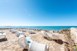 a sandy beach with tables and chairs and the ocean at Westpoint Dakhla in Dakhla