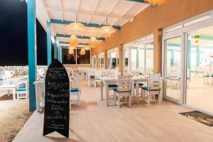 a dining room with tables and chairs and a surfboard at Westpoint Dakhla in Dakhla