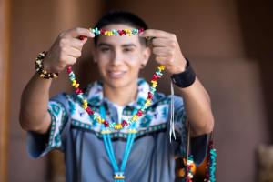 un joven sosteniendo un collar de cuentas en su cabeza en Hyatt Regency Tamaya South Santa Fe, en Santa Ana Pueblo