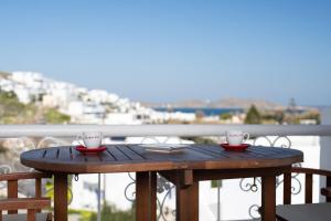 a wooden table with two coffee cups on a balcony at VILLA KOSTA in Naousa-Paros in Naousa