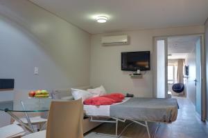 a room with a bed and a television in it at Regency Rambla Design Apart Hotel in Montevideo