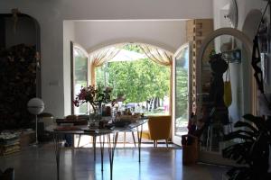 a dining room with a table and a large window at Angeli di Montefiore in Montefiore dellʼAso