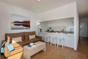 sala de estar con sofá y cocina en Rocas Blancas Apartments, en Puerto del Carmen