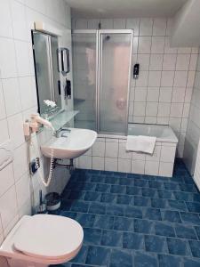 ein Bad mit einem WC, einem Waschbecken und einer Dusche in der Unterkunft Hotel Kirchdach in Gschnitz