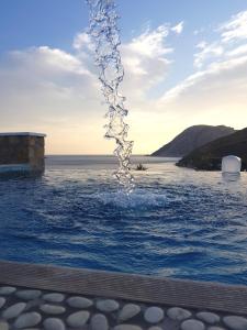 a fountain in the middle of a body of water at Alykes Studios in Grikos