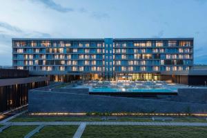 a large building with a pool in front of it at Grand Hotel de Kintele in Brazzaville