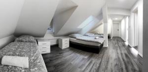 a attic bedroom with two beds and a mirror at Hotel Kotva in Hřensko