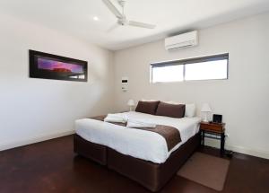 1 dormitorio con 1 cama grande y ventilador de techo en Alice On Todd Apartments, en Alice Springs