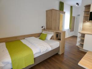 a bedroom with a bed with a green and white blanket at Living Hallertau in Rudelzhausen