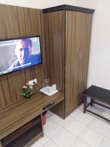 a room with a tv and a wooden cabinet at SAROVAR INN in Chennai