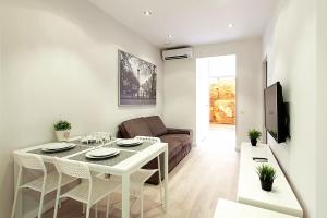 ein Wohnzimmer mit einem weißen Tisch und einem Sofa in der Unterkunft MIQUEL ANGEL - Apartments with community terrace in Barcelona