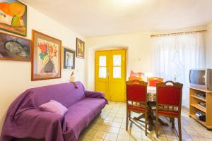 a living room with a purple couch and a table at Crni in Drenje
