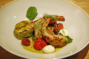 a white plate of food with shrimp and vegetables at Hotel Indigo Helsinki-Boulevard by IHG in Helsinki +84 photos