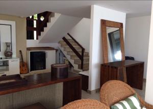 uma sala de estar com uma escada e um espelho em Casa na praia em condomínio de luxo - Porto Brasil Resort em Parnamirim