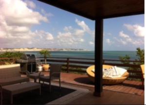 a view of the ocean from the balcony of a house at Casa na praia em condomínio de luxo - Porto Brasil Resort in Parnamirim