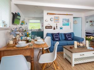 a living room with a blue couch and a table at The Hut in Dartmouth