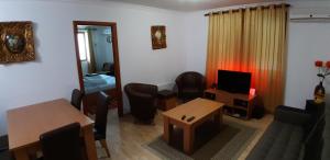 パンポロボにあるPamporovo Monastery 3 Apartmentのリビングルーム(テーブル、椅子、テレビ付)