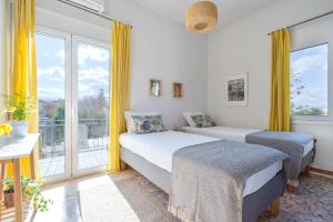a bedroom with two beds and a balcony at Sea,City & Mountain View Apartment in Chania Town